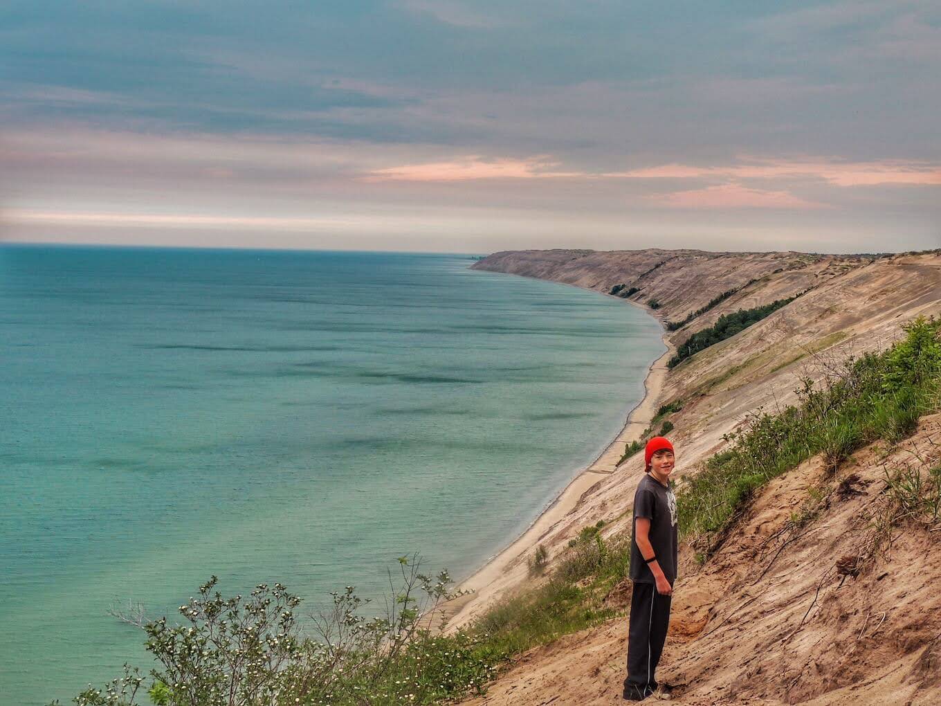 Una persona de pie frente a un paisaje de playa para demostrar la escala en la fotografía de la naturaleza.